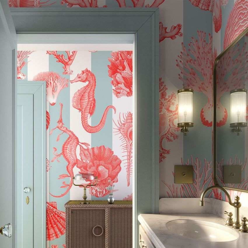 Art deco bathroom mockup with coral and light blue wallpaper featuring sea creatures, a marble sink, gold faucet, and wall sconce lighting.