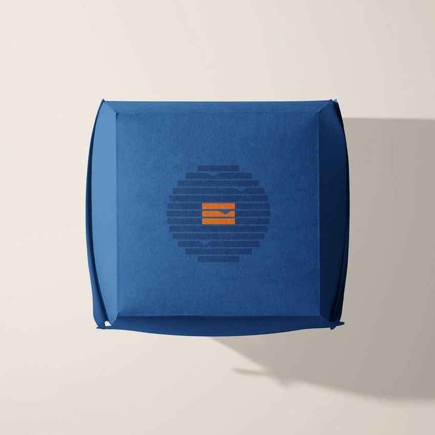 Blue burger box mockup viewed from above, featuring a circular graphic with orange and dark blue elements on a light background.