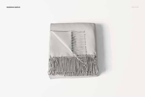 Folded fringe blanket in light gray color shown from a top view, with one corner wrapped to reveal detailed tassels.