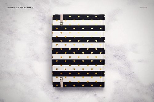 PSD mockup of a stationery planner with gold heart accents and striped design, displayed on a textured light surface.