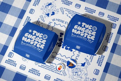 PSD mockup featuring two blue rectangular burger boxes with white branding, placed on illustrated food-themed wrapping paper.