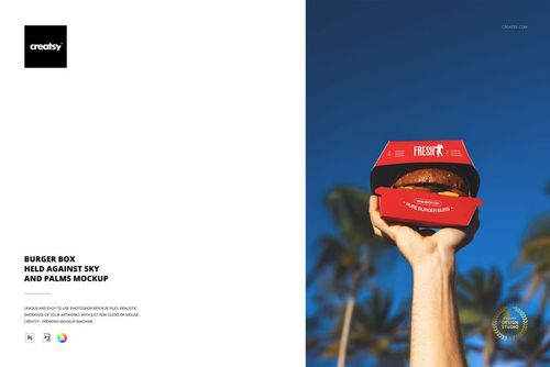 Burger box mockup in a person’s hand, featuring a red package and burger, set outdoors with tropical palms.