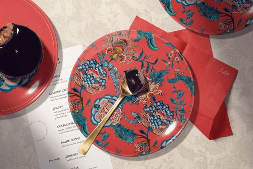 PSD mockup showing a patterned ceramic plate, red napkin, dessert, and menu on a light textured tabletop.