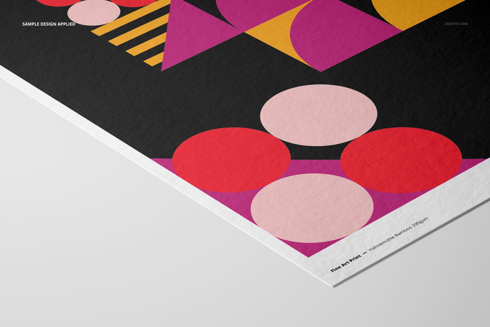 A3 fine art print mockup featuring geometric shapes in pink, purple, yellow, and red on a black background, angled view.