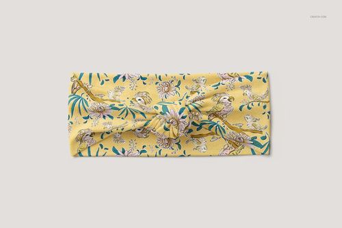 Yellow twist knot style headband for children displayed flat, decorated with flowers and birds in a mockup scene.