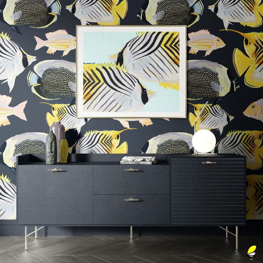 Interior wallpaper mockup featuring a dark wall with a bold fish pattern, a framed fish artwork, and a modern sideboard with decorative objects.