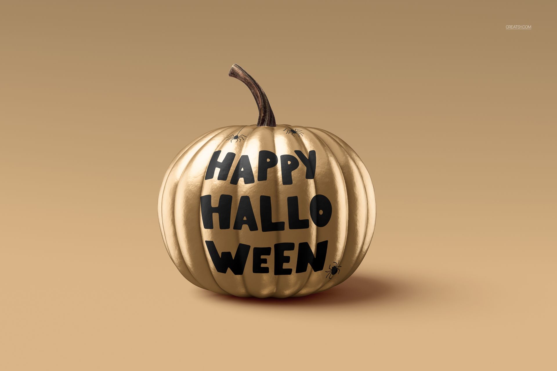 Golden pumpkin mockup with bold black Halloween text and spider graphics, displayed against a neutral backdrop.
