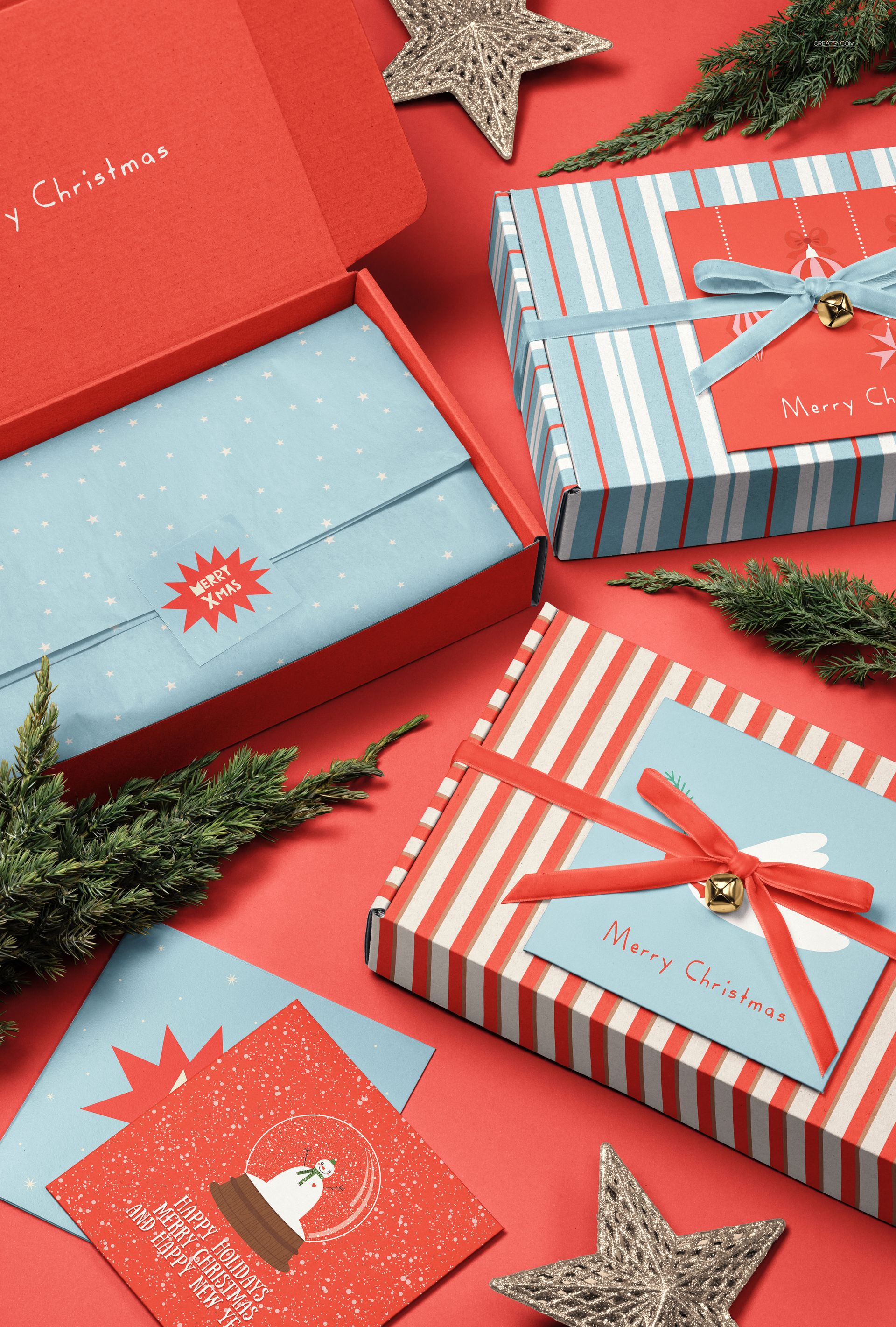 PSD mockup featuring Christmas-themed gift packaging, star ornaments, and greenery, arranged flat lay style.