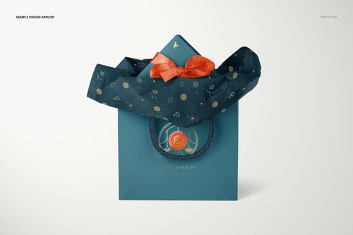 Jewelry box and bag PSD mockup featuring blue packaging, patterned tissue paper, and decorative orange accents in a studio setting.