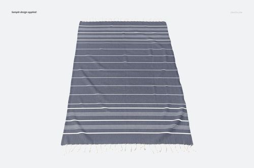 Flat lay of a Turkish tassel towel mockup featuring white horizontal stripes on a solid gray surface.