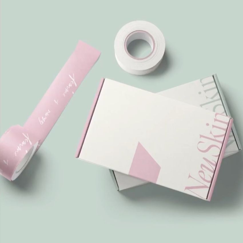 Mailing box mockup with a minimal design in soft pink and white, shown with matching tape on a pale green background.