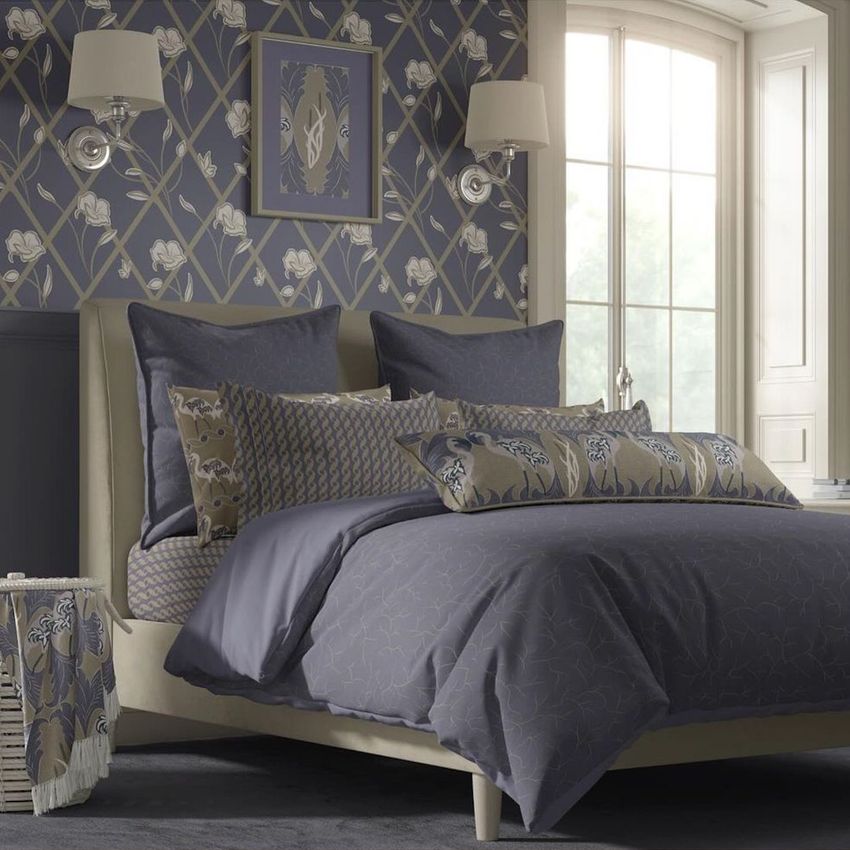 Cottage style bedroom bedding mockup featuring a neatly made bed with patterned pillows and a purple comforter in a cozy room.