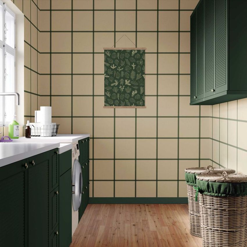 Laundry room mockup with green cabinets, a washing machine, wicker baskets, and a patterned wall hanging on a grid wall.