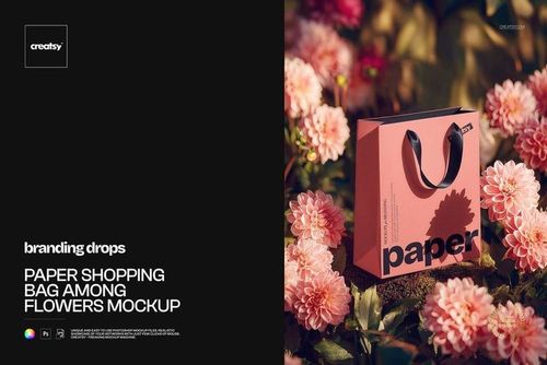 PSD mockup showing a pink paper shopping bag with black handles surrounded by vibrant pink flowers outdoors.