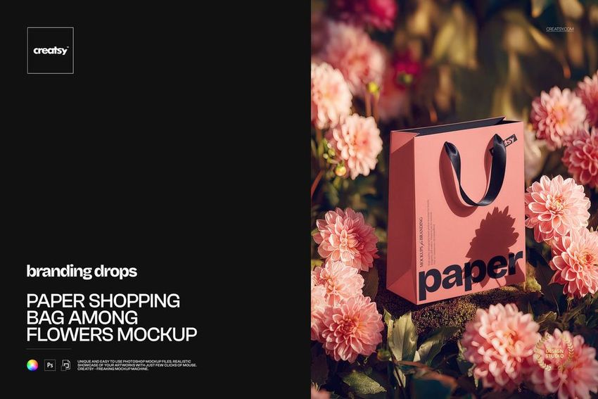 PSD mockup showing a pink paper shopping bag with black handles surrounded by vibrant pink flowers outdoors.