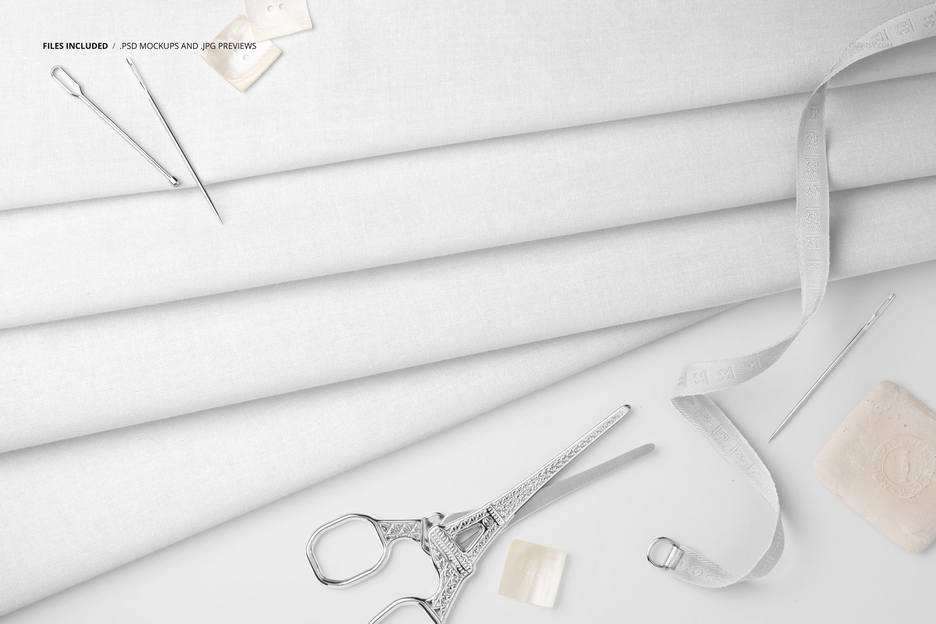 PSD mockup showing layered cotton fabric with tailoring items such as measuring tape, needles, and scissors arranged nearby.