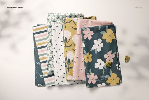 PSD mockup of several folded textile pieces with assorted pastel flower, stripe, and polka dot patterns, top perspective.