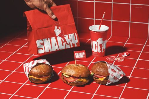Fast food restaurant PSD mockup featuring burgers, a paper bag, and a drink cup with red branding on tiles.