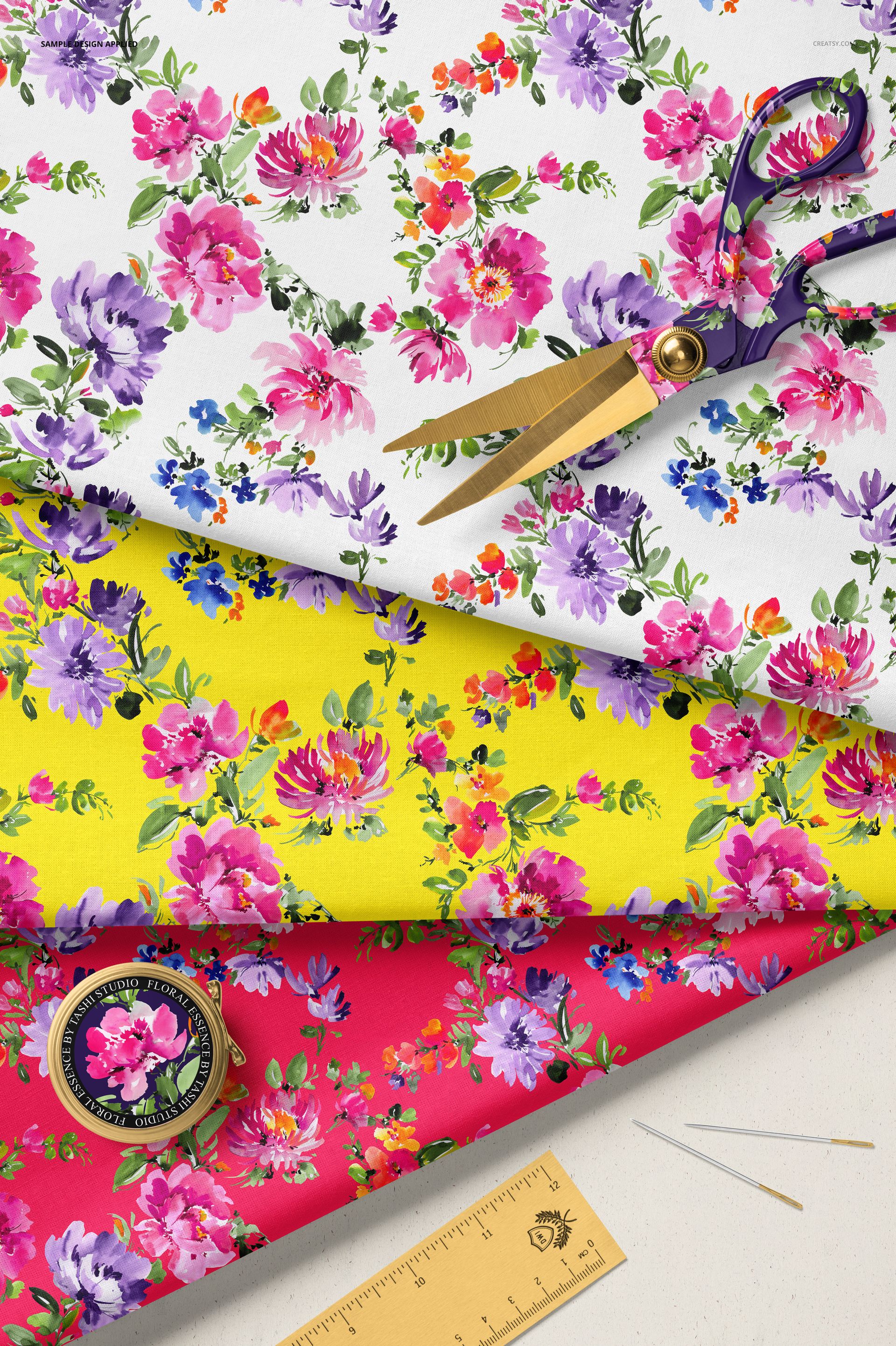 PSD mockup featuring colorful cotton fabrics with flower prints, displayed alongside scissors, ruler, and needles.