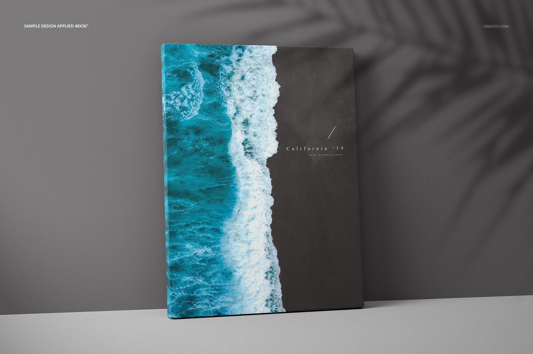 Front view of a thick canvas print mockup with ocean wave artwork, standing against a gray wall with shadow pattern.