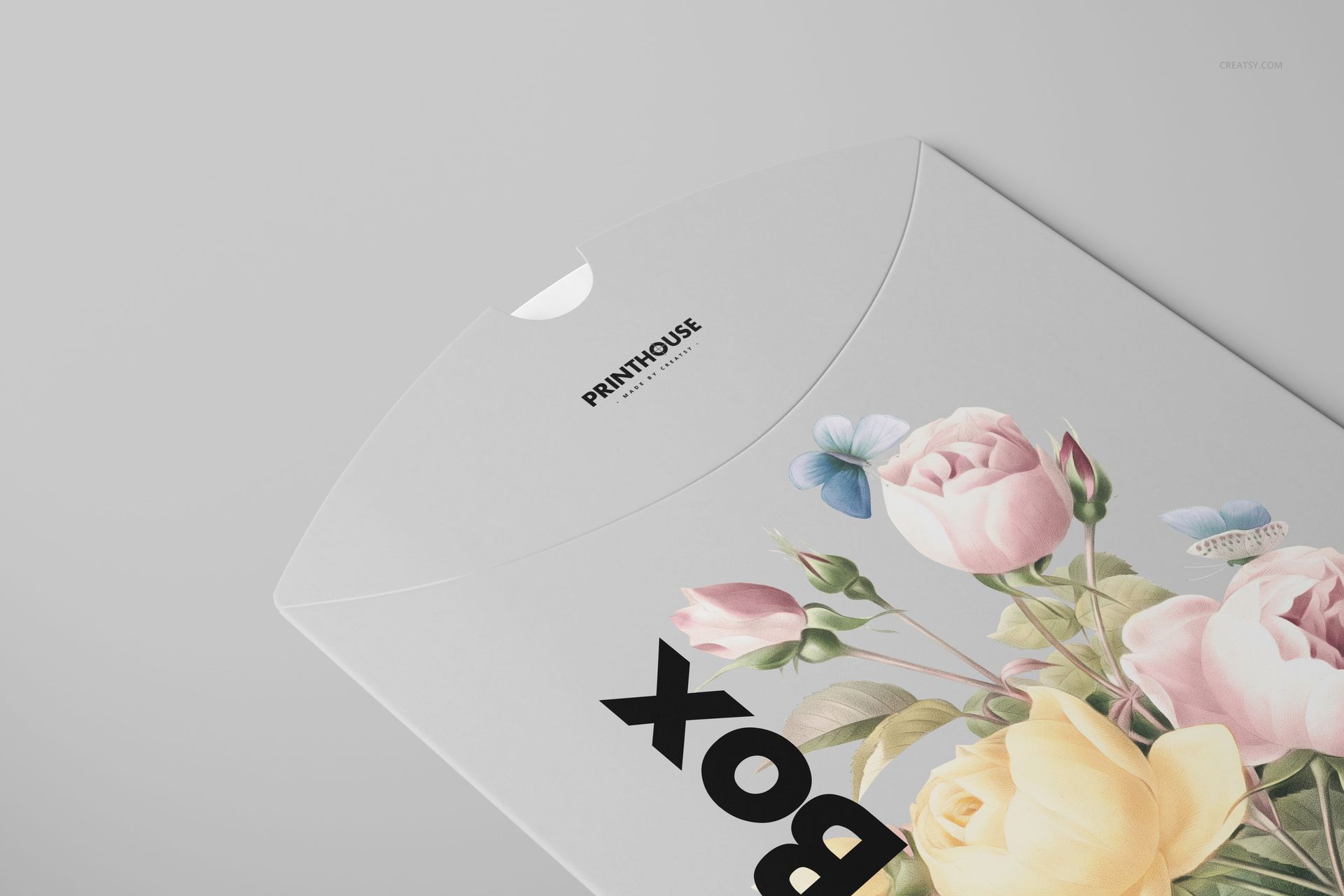 PSD mockup of a matte pillow box featuring pastel flowers and butterflies, displayed from a top angled perspective.