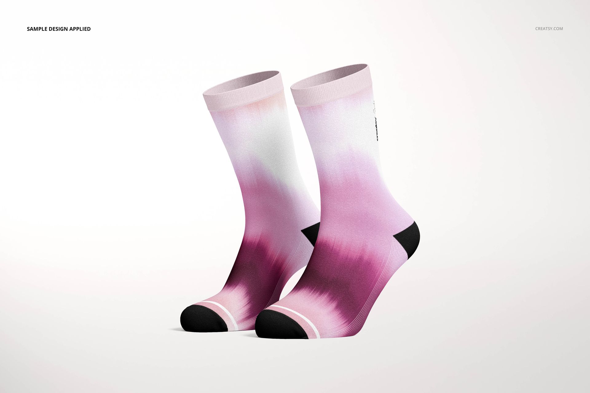 Two fashion socks featuring a soft pink ombre design with black accents, displayed side by side in a PSD mockup scene.