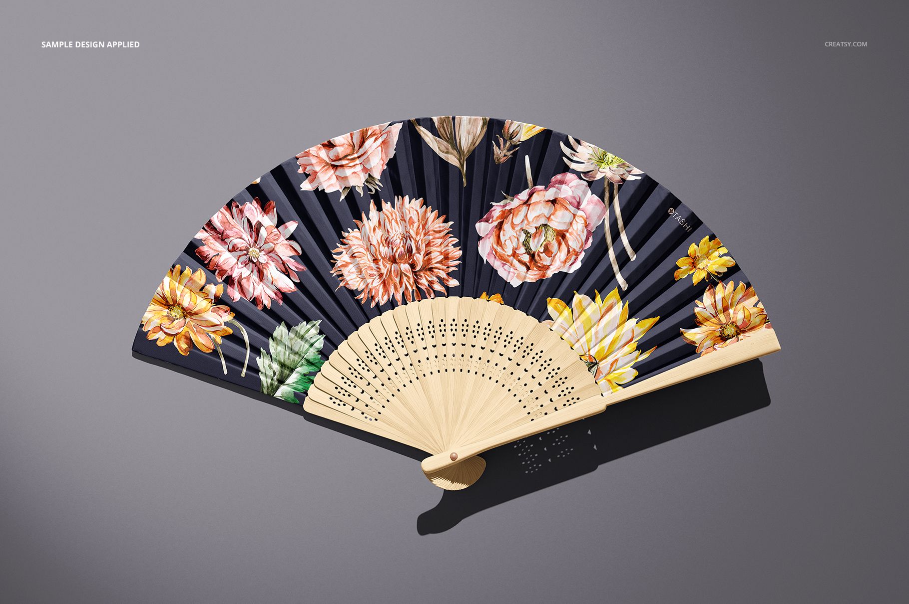 PSD mockup of a fabric hand fan with vibrant flower designs and light wooden elements shown from above.