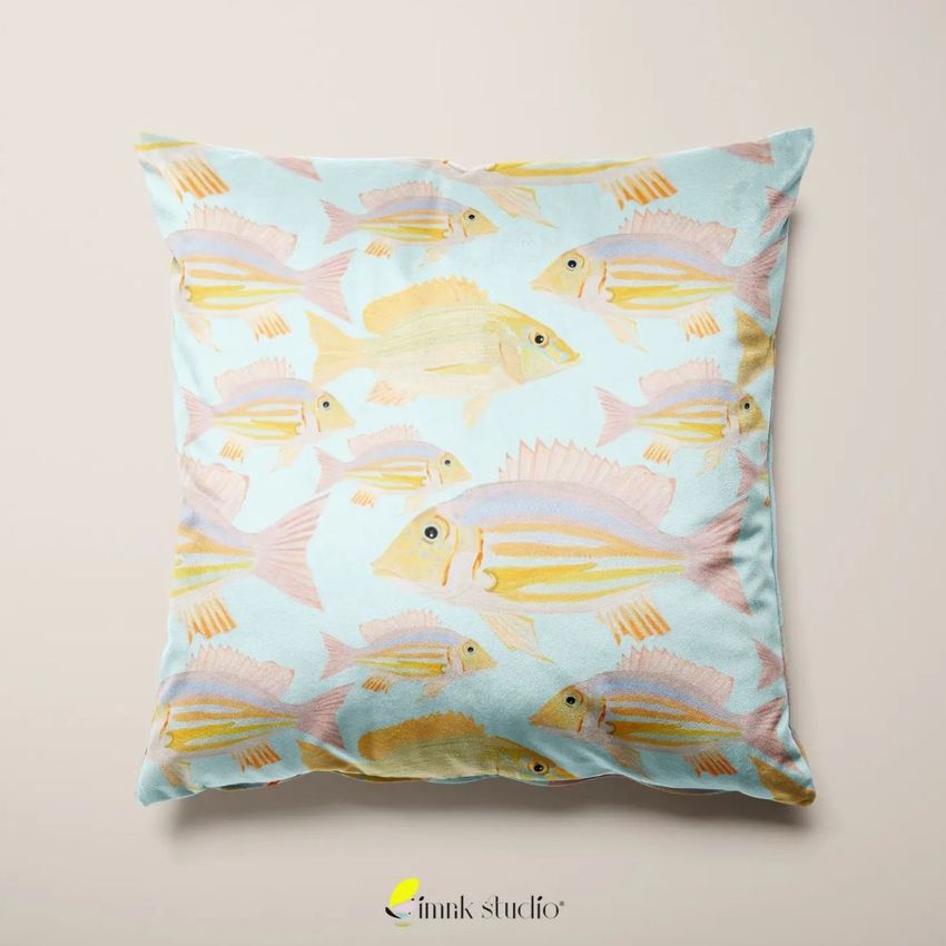 Velvet cushion cover mockup featuring a square pillow with a pastel fish pattern on a light blue background, shown on a neutral surface.