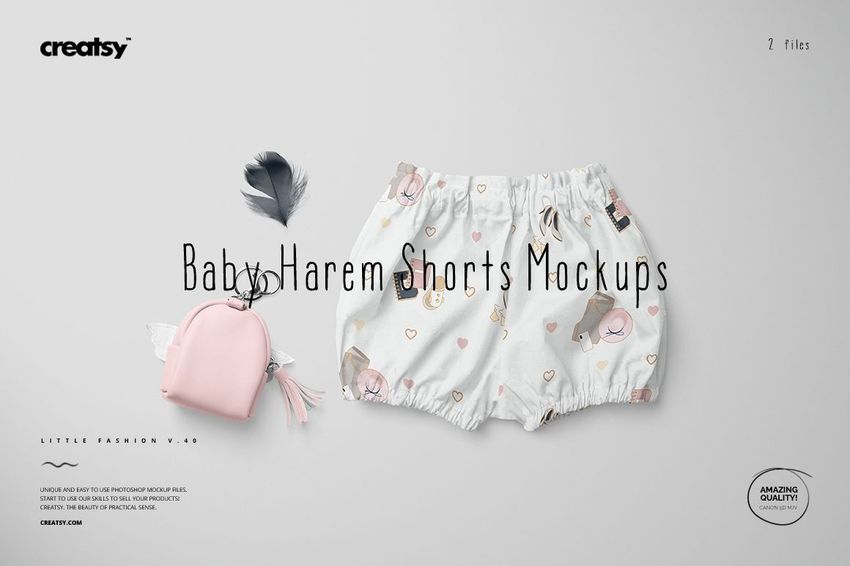 Baby harem shorts mockup featuring a white fabric with cartoon animals and hearts, shown alongside a pink pouch and feathers.