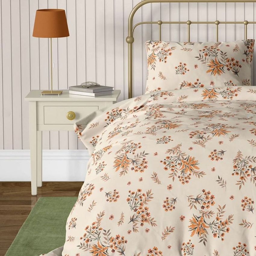 Vintage bedroom bedding mockup featuring a floral-patterned duvet and pillow on a brass bed, beside a cream nightstand.