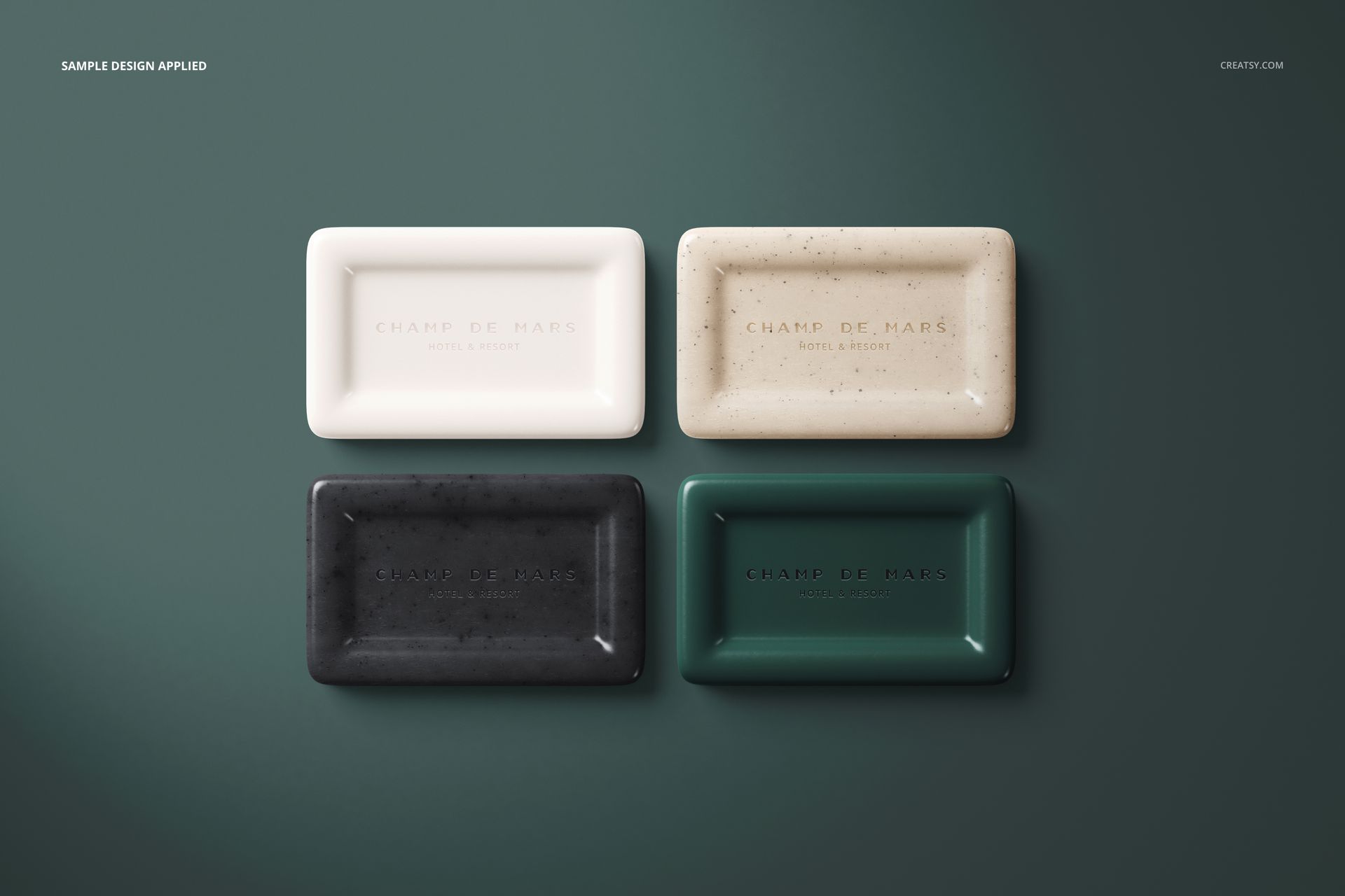 PSD mockup showing assorted hotel hand soap bars with embossed text, neatly placed side by side on a green surface.