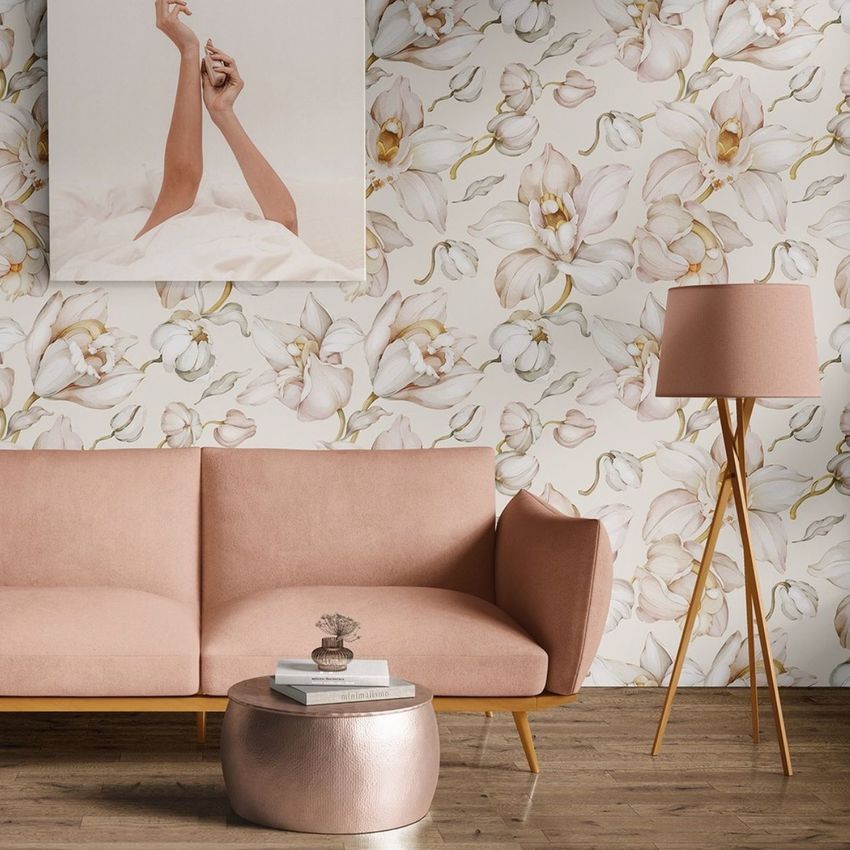Interior scene mockup featuring a blush pink sofa, round ottoman, and tripod floor lamp against a floral wallpaper background.