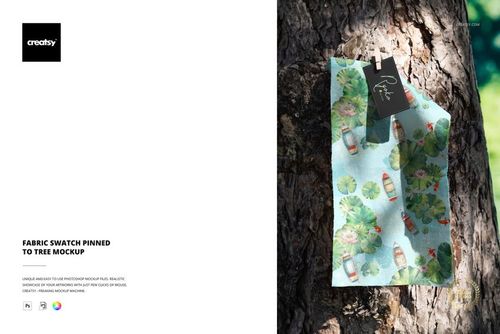 PSD mockup displaying a fabric swatch with a playful aquatic design, pinned vertically to the bark of a tree outdoors.