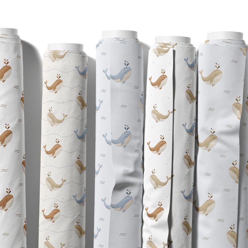Fabric rolls mockup featuring six upright rolls with repeating whale patterns in muted blue, beige, and brown tones on white backgrounds.