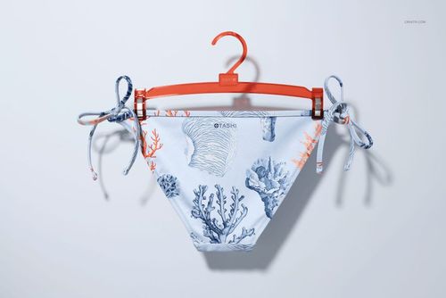 Front view of bikini bottom mockup with blue and orange coral pattern, displayed on an orange hanger against a light background.