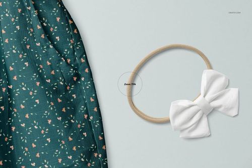 PSD mockup showing detailed green floral baby pants and a soft white bow headband arranged on a pale background.