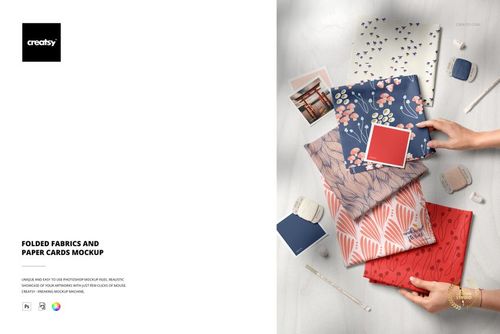 PSD mockup featuring multiple folded fabrics in different prints, paired with paper cards and small desk accessories.