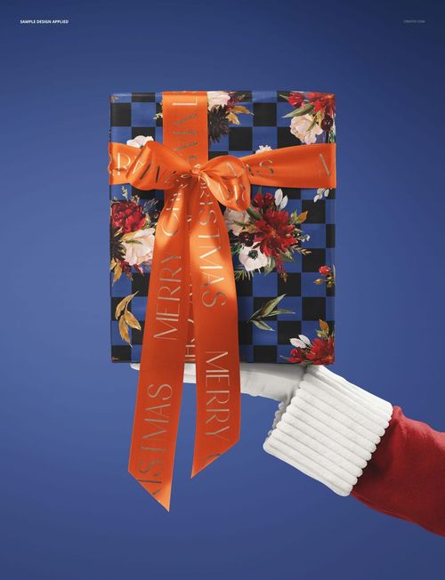 PSD mockup showing Santa holding a festive gift box decorated with floral patterns and a bright orange bow, front perspective.
