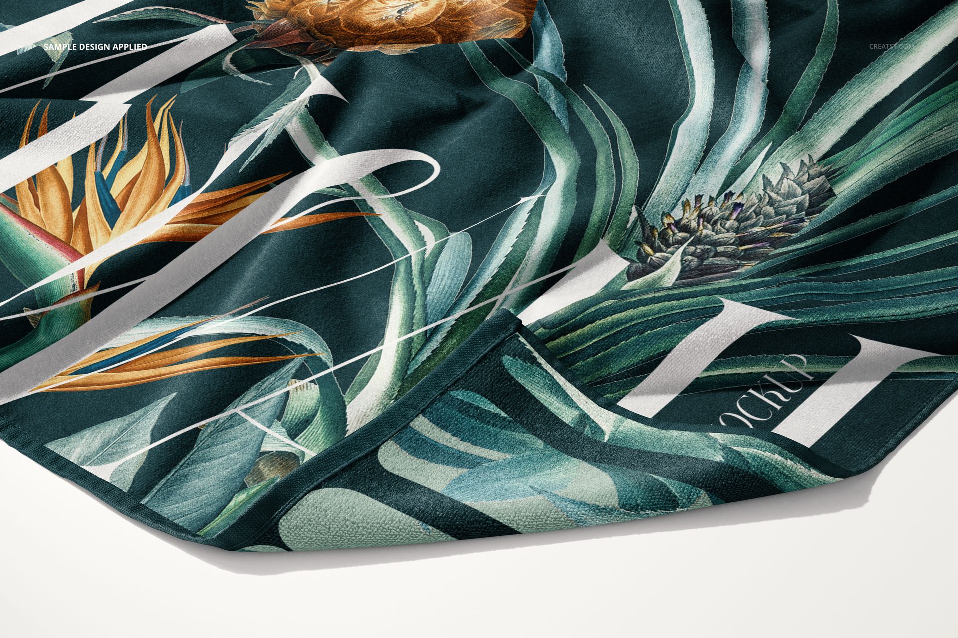 Detailed PSD mockup of a beach towel featuring botanical prints with lush green leaves and orange flowers on fabric.