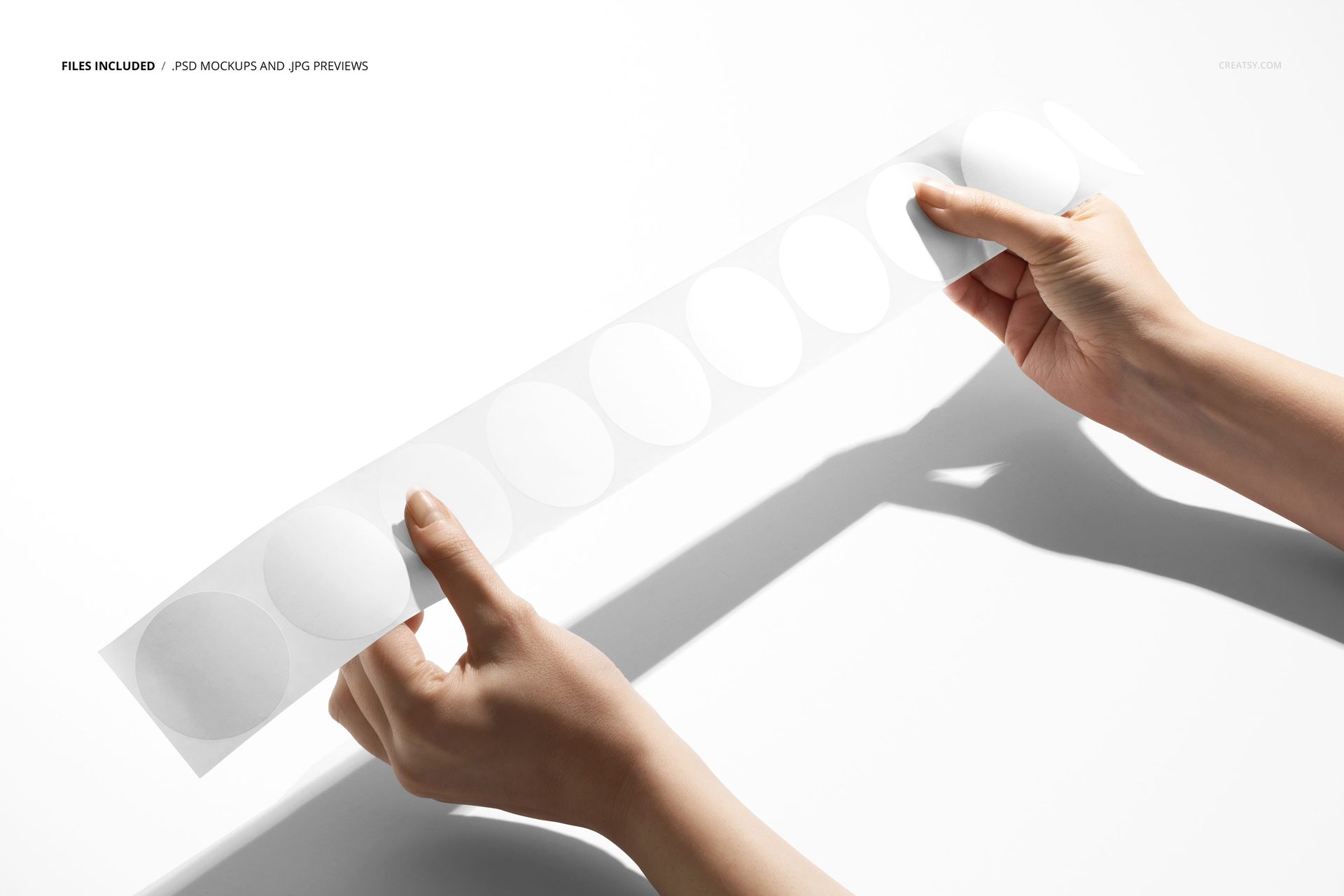 Hands holding a strip of round white stickers against a bright background, showing the packaging design mockup.