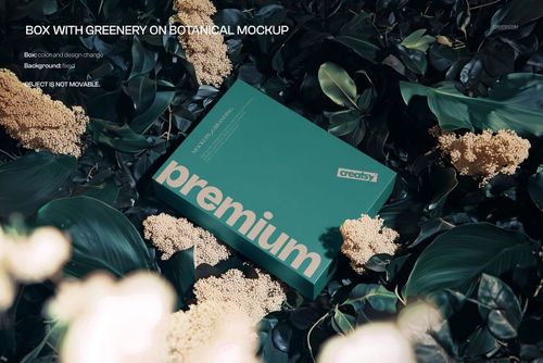 Teal PSD mockup box with bold text surrounded by lush green foliage and clusters of pale flowers, viewed from above.