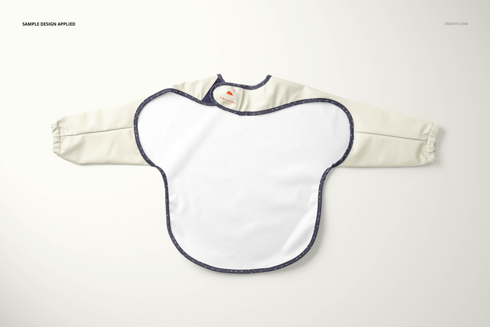 Baby sleeved bib mockup displayed from a top view, featuring cream-colored sleeves and a white front panel.