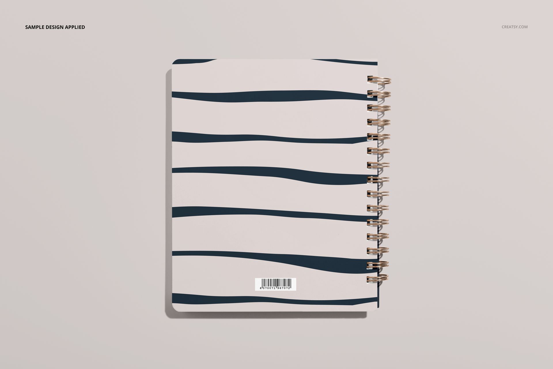 Little coiled notebook mockup showing a spiral-bound cover with dark blue wavy lines on a pale background.