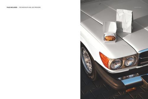 PSD mockup showing burger packaging with a white paper bag and box placed on a vintage car hood, photographed from above.