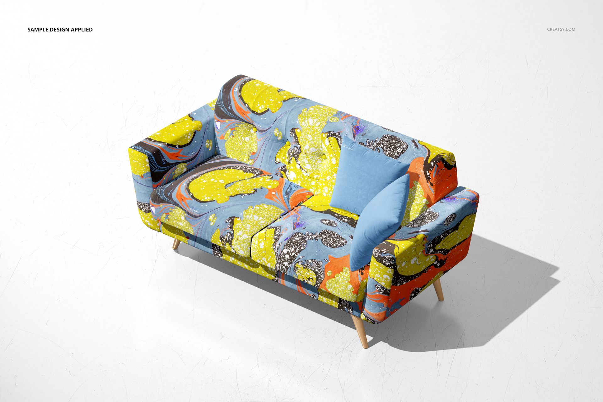 Contemporary sofa mockup featuring vibrant marbled design in blue, yellow, and orange, displayed on a plain white surface.