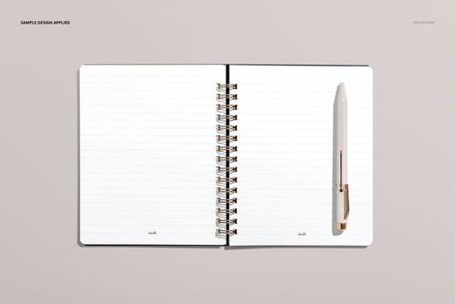Little coiled notebook mockup showing blank lined sheets and a white pen, displayed flat on a light beige tabletop.