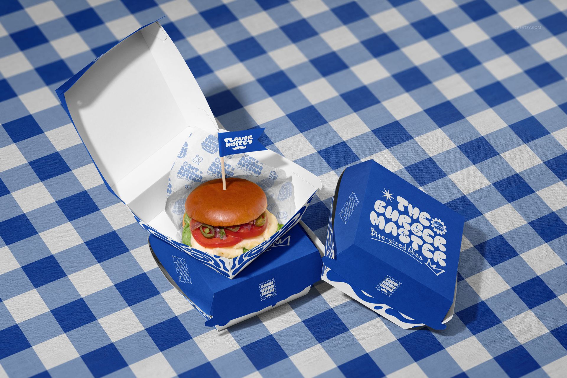PSD mockup of vegan burger packaging featuring blue and white boxes, displayed from a top angle on a patterned cloth.