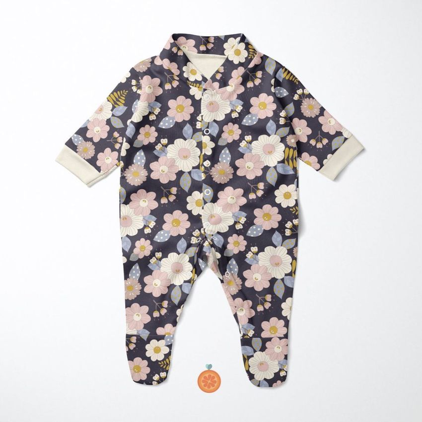 Babygrow sleepsuit mockup featuring a floral pattern with pink, white, and yellow flowers on a dark background, laid flat on a light surface.