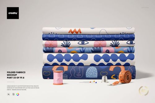 Front view of folded fabrics mockup featuring various designs in blue, pink, orange, and white tones, with sewing props.