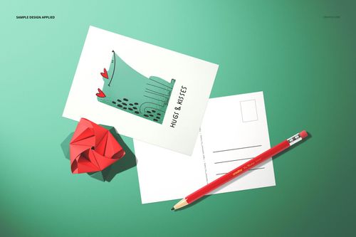 Top view of a paper Valentines card mockup set with illustrated card, blank postcard, red pencil, and paper rose.
